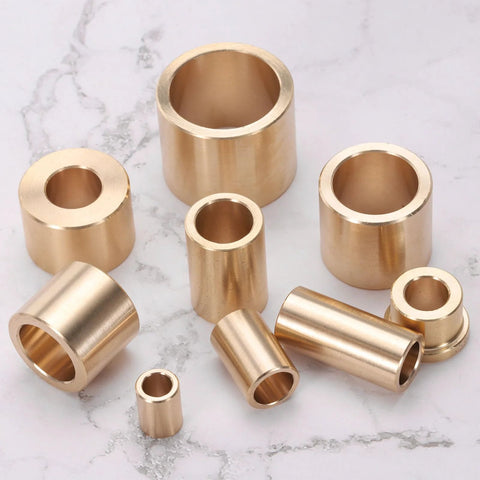 Set Of Four Self Lubricating Brass Sleeve Bearings Three Eighths Inch Bore One Half Inch Outer Diameter Three Quarters Inch Length Brass Bushing For Low Friction Linear Motion Applications displayed on marble surface.