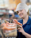 Worker in a factory wearing an Anti Static Cleanroom Hat Breathable Working Cap focusing on quality control of products.