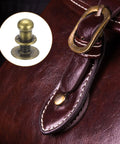 Close-up of bronze 5mm Ball Head Stud Rivets With Screw Back on leather handbag, showcasing nipple rivet design and buckle detail.