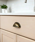 Brass Bronze Cup Drawer Pull on kitchen cabinet, features 3-inch center to center spacing, part of Twelve Pack Cabinet Cup Pulls Set for furniture.