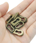 Hand holding 8Pcs Bronze Skeleton Key Covers For Furniture Keyholes Zinc Alloy Antique Style Keyhole Lids.