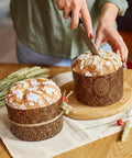 Person slicing Easter bread in 48 Pack Easter Panettone Paper Molds 15 Oz Nonstick Brown Round Paska Kulich Baking Molds Pans