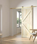 Gold Barn Door Hardware Kit With 84 Inch Track For 7 Foot Sliding Door Modern Brushed Brass Finish Includes All Mounting Hardware For One Door Adjustable Track From 39.35 Inches To 84 Inches installed on a wooden door in a bright room.