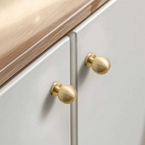 One Inch Gold Ball Cabinet Knobs Set Crafted From Solid Brass With Hand Brushed Finish installed on white cabinets