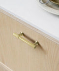 5 Inch Hole Center Cabinet Pulls 10 Pack Brushed Brass Solid Zinc Alloy Hardware installed on light wood cabinet