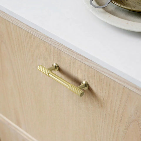 5 Inch Hole Center Cabinet Pulls 10 Pack Brushed Brass Solid Zinc Alloy Hardware installed on light wood cabinet
