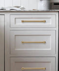 Two Pack 12 Inch Center To Center Brushed Brass Cabinet Pulls Set on white dresser with modern design