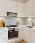 Modern kitchen with 5 Inch Hole Center Cabinet Pulls 10 Pack Brushed Brass Solid Zinc Alloy Hardware on white cabinets.