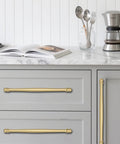 2 Pack 4 Inch Center To Center Brushed Gold Cabinet Pulls installed on gray kitchen drawers with marble countertop