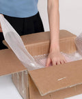 Person using 2 Pack 12 Inch Bubble Packing Wrap 72 Feet Perforated Every 12 Inches for Moving Boxes and Shipping Cushioning