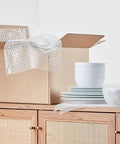 Bubble Cushioning Wrap For Fragile Items Perforated 12 Inch Roll 175 Ft Clear With Small Three Sixteenth Inch Bubbles next to dishes