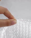 Close-up of a hand tearing perforated 2 Pack 12 Inch Bubble Packing Wrap 72 Feet Perforated Every 12 Inches for Moving Boxes and Shipping Cushioning.