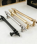 Collection of elegant cabinet handles in gold, silver, and black finishes displayed on a white surface.