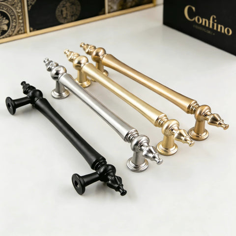 Collection of elegant cabinet handles in gold, silver, and black finishes displayed on a white surface.