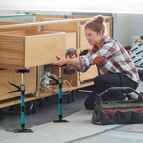 Woman using adjustable support poles, cabinet jacks for installing cabinets, telescoping support poles range from 13.8'' to 24.6'', 2 packs