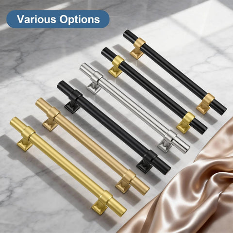 Various cabinet pulls in black, gold, and silver finishes displayed on marble surface.