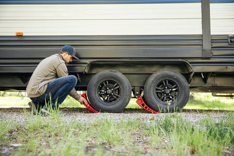 Person using Camper Leveler Block With Rubber Mat for RVs and Trailers, precise leveling from one half inch to four inches.
