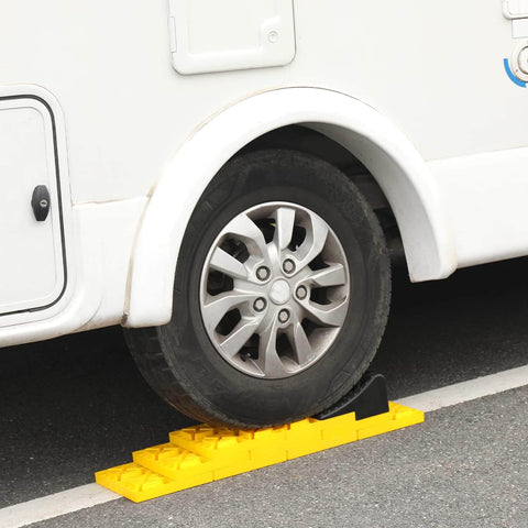 RV tire on yellow interlocking camper leveling blocks kit with anti slip ramps 10 pack includes one wheel chock and handy carrying bag for travel trailer and RV no slip rock solid stabilization on uneven ground