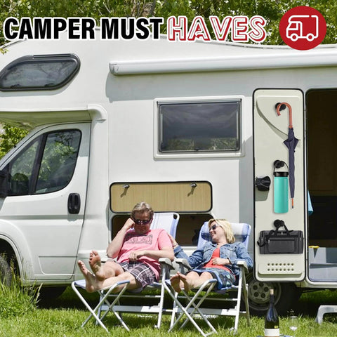 Two people relaxing outside a camper van with camping essentials like a water bottle, umbrella, and bag attached to the side.