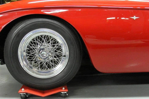Red car on Car Dolly Replacement Casters Set of 4-1500 Lbs. Capacity showing front wheel and dolly in garage setting.