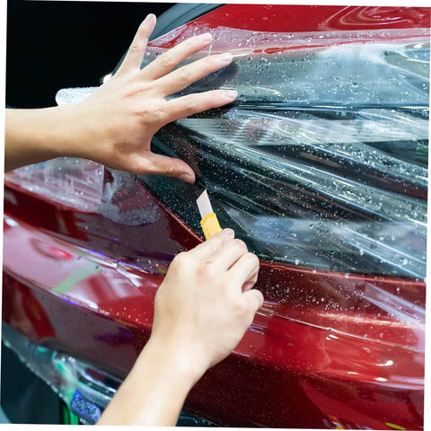 Hands installing protective film on red car headlight using cutting tool, focusing on Multifunction Home Repair Tool Kit With Handy Storage Case For DIY Projects And Maintenance All In One Handyman Set For Home Garage And Workshop Includes Essential Tools For Quick Fixes And Everyday Repairs.