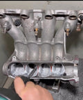 Sworker long carbide burr attached to a die grinder used on a metal engine cylinder head