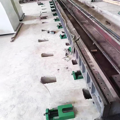 Heavy Duty Cast Iron Machine Leveling Feet Pads Set installed, supporting CNC machinery on uneven floor in industrial setting