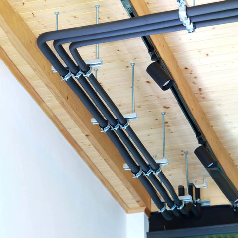 Ten-piece universal tube clamps deliver secure, corrosion-resistant support for Unistrut channels; 2 inch wall mount conduits, installed.