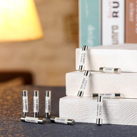 FF10A 600V Fast Blow Ceramic Fuses For Multimeters DMMs 6.3x32 Mm 10 Amp displayed on books in warm lighting.