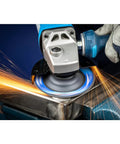 A close-up of CC Grind Robust Grinding Disc by PFERD in use, sparks flying during aggressive grinding on metal with fiberglass backing.