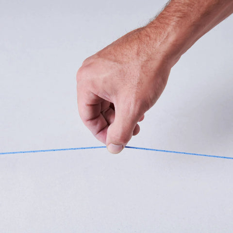 Hand holding blue line from Durable ABS Tuff Line contractor chalk reel delivers precise layout marking, ideal for construction.