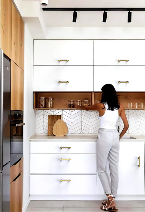 Modern kitchen with Champagne Bronze Cabinet Pulls 3 Inch Center To Center 76mm on white cabinets, woman reaching for glassware