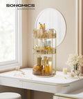 Three Tier Round Rotating Makeup And Skincare Organizer for countertop vanity in champagne gold, filled with cosmetics, reflected in a mirror.