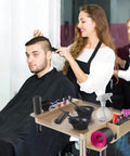 Champagne Gold Pro Grade Hair Salon Cart with wheels and height adjustable tray in use during a haircut at a salon.