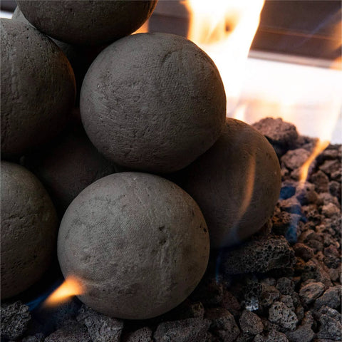 Charcoal Gray 2 inch Ceramic Fire Balls - 30-Pack - Brushed Concrete Look, Speckled in a fire pit with flames.