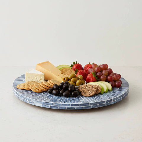 12.6 inch mother of pearl lazy susan turntable with blue starburst design featuring cheese, fruits, and crackers on a decorative tray.