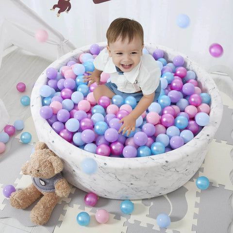 Child playing in marble ball pit with Ball Pit Balls - 100pcs - Crush Proof Plastic Children's Toy Balls Macaron Ocean Balls for parties