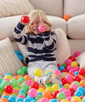 Child playing in colorful BPA Free Crush-Proof Plastic Ball Pit Balls with Storage Bag, Toddlers Kids 12+ Months, Pack of 400 Balls, 6 Bright Colors
