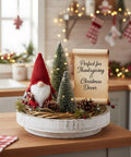 Holiday-themed kitchen counter decor with a white round tray, gnome, mini trees, pinecones, and a sign reading 'Perfect for Thanksgiving & Christmas Decor.'