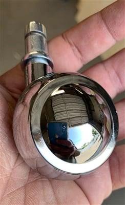 Hand holding a chrome-plated 1.5 inch Shepherd ball caster wheel for smooth motion in automation systems, single item close-up