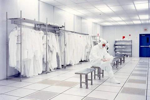 Cleanroom environment with person in protective gear, emphasizing use of White PVC Cleanroom Tape 2 Inch By 36 Yards One Roll That Handles Solvents
