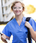 Person wearing Clear Anti Fog Safety Glasses With Anti Scratch ANSI Z87 1 Blue Light Blocking, holding clipboard and backpack.