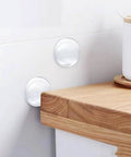 6 Pack Clear Door Stopper Wall Protectors, 2 Inch Round Self Adhesive Cushions installed on a white wall near a corner of a wooden countertop