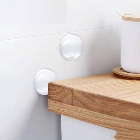 6 Pack Clear Door Stopper Wall Protectors, 2 Inch Round Self Adhesive Cushions installed on a white wall near a corner of a wooden countertop