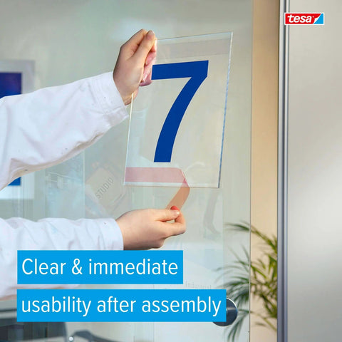 Sticks Like A Champ Transparent Double Sided PET Film Tape For Clean Mounting 0.5 Inch Wide By 108 Foot Roll With Tackified Acrylic Adhesive High Temperature Resistance Industrial Grade applied to glass by a person.