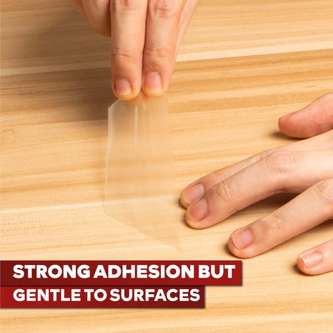 Clear Double Sided Tape Removable 1.5 Inch By 30 Yards being peeled off wood surface showing strong adhesion and gentle removal