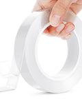 Heavy Duty Double Sided Tape Clear Removable Mounting Tape, transparent roll, held in hand, showing adhesive side