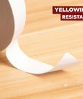 Close-up of Clear Double Sided Tape Removable 1.5 Inch By 30 Yards unrolled on wooden surface, yellowing resistant.