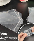 Person holding 400 Pcs Clear 3x4 Inch Jewelry Bags 2 Mil Resealable Zip Bags for Small Business Storage Candy showcasing durability.