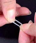 Close-up of clear rubber dampener from 200 Pieces O Ring Keyboard Dampeners For MX Switches And Mechanical Keys, being held by fingers.